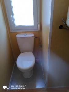 a small bathroom with a toilet with a window at CASITA AZUL MUÑICO , AVILA in Muñico