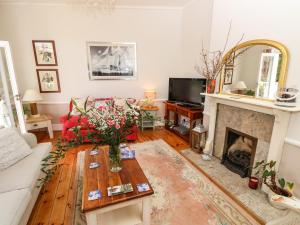 sala de estar con sofá y chimenea en The Maltings en Freshwater