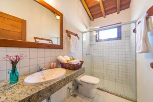 y baño con lavabo, aseo y ducha. en Charm Bahia Residencias, en Arraial d'Ajuda