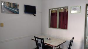 a dining room with a table and a tv on the wall at Alto Unimev in Mendoza