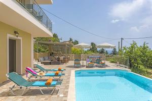 - une piscine avec des chaises longues et des chaises à côté d'une maison dans l'établissement Villa Vounaki by Villa Plus, à Lourdhata