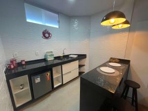 een keuken met een zwart aanrecht en een wastafel bij Central Praias Suite 1 in Cabo Frio