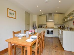a kitchen and dining room with a wooden table and chairs at Butterbrook Coach House in Harford