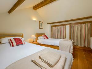 a bedroom with two beds and a window at Butterbrook Coach House in Harford