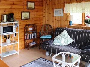 ein Wohnzimmer mit einem Sofa und Holzwänden in der Unterkunft 4 person holiday home in EKER in Ekerö