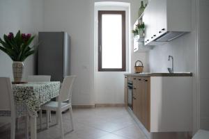 Il comprend une cuisine et une salle à manger avec une table et un réfrigérateur. dans l'établissement Al muro casa vacanza, à Leverano