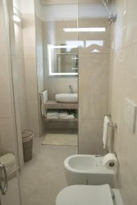 La salle de bains est pourvue de toilettes blanches et d'un lavabo. dans l'établissement Al muro casa vacanza, à Leverano