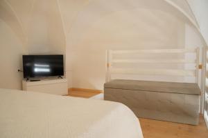 una camera con letto e TV a schermo piatto di Al muro casa vacanza a Leverano