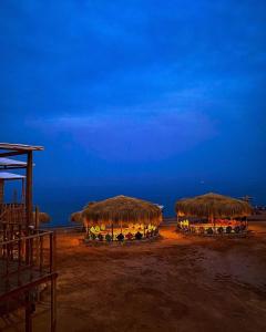 a group of straw umbrellas on the beach at night at sea horse in Nuweiba