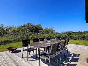a wooden table and chairs on a wooden deck at 6 person holiday home in Hirtshals in Hirtshals
