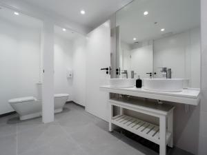 a white bathroom with two sinks and a toilet at Hostel Charino in Pontevedra