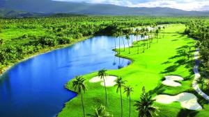 a golf course with palm trees and a river at Cozy suite at coco Beach , not pets in Rio Grande