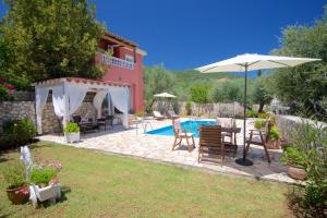 een patio met een parasol en een zwembad bij Villa Marina Epavlis by Villa Plus in Karavomylos