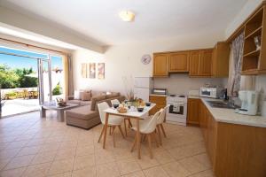 een keuken en een woonkamer met een tafel en een bank bij Villa Marina Epavlis by Villa Plus in Karavomylos