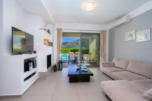 a living room with a couch and a table at Villa Rubi by Villa Plus in Karavomylos