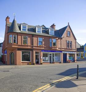 a large brick building on the corner of a street at Knap Guest House in Tarbert