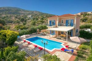 a villa with a swimming pool and a house at Villa Skala Beachview by Villa Plus in Spathíon