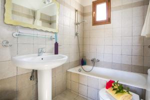 a bathroom with a sink and a toilet and a tub at Villa Sandy Cove by Villa Plus in Spartia +12 photos