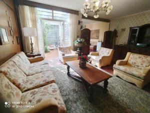 uma sala de estar com um sofá, cadeiras e uma mesa em Suite Simples Boa Barata 10 min Metro e Aeroporto CGH em São Paulo