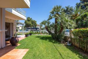 a yard with palm trees and a fence at Danae Comfort Living in Pefkochori