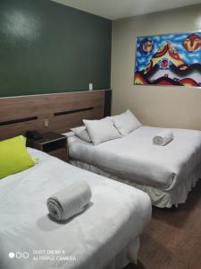 una habitación de hotel con 2 camas y un cuadro en la pared en Hostal NAVAL en La Paz