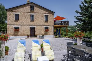 a group of chairs and a table in front of a building at Casa Friano in Amandola
