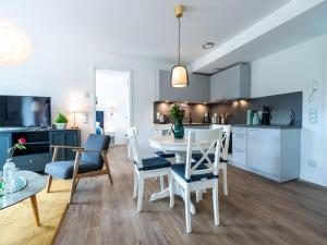 eine Küche und ein Wohnzimmer mit Tisch und Stühlen in der Unterkunft Dünenresidenz Prora - Ferienwohnung mit 2 Schlafzimmern und Balkon B3-2-3 in Binz