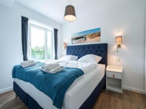 ein Schlafzimmer mit einem blau-weißen Bett und einem Fenster in der Unterkunft Dünenresidenz Prora - Ferienwohnung mit 2 Schlafzimmern und Balkon B3-2-3 in Binz