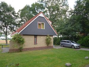 ein kleines Haus mit einem Auto auf einem Hof in der Unterkunft Restful Holiday Home in Lemele with a Spacious Garden in Lemele