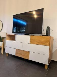 een flatscreen-tv op een dressoir bij Cálido depto 2 personas- Zona residencial in Morón