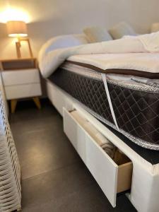 1 dormitorio con 1 cama con cajones blancos en Cálido depto 2 personas- Zona residencial en Morón