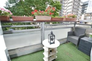 un balcón con macetas y una mesa con lámpara. en Garden Tower flat, en Londres