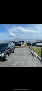 a black van parked on the side of a road at Modern Apartment With City & Oceanside View in Tórshavn