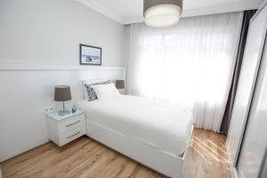 a white bedroom with a bed and a window at Patika Suites in Istanbul