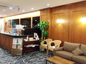 a lobby with a waiting room with a couch and chairs at Hotel Abest Naha Kokusai Street in Naha