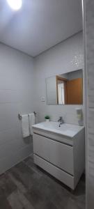 a white bathroom with a sink and a mirror at Atlantico in Geres +52 photos