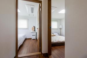 um espelho num quarto com uma cama e um quarto em Haevichi Private Pension em Seogwipo