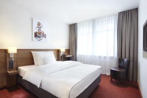 a hotel room with a large bed and a large window at Hotel Hafen Hamburg in Hamburg