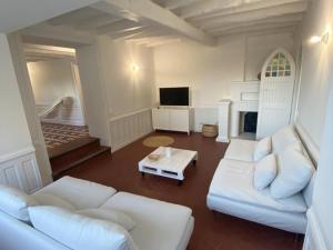 sala de estar con 2 sofás blancos y chimenea en Gîte Senlisse, 4 pièces, 6 personnes - FR-1-527-11, en Senlisse