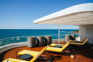 eine Terrasse auf einer Yacht mit Stühlen und einem Sonnenschirm in der Unterkunft The Surf Yamba in Yamba