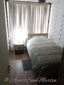 a bedroom with a bed and a window at Apart San Martín Departamento 2d 1b in Santiago