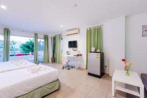 a hotel room with two beds and a desk and a kitchen at Little Home Ao Nang in Ao Nang Beach