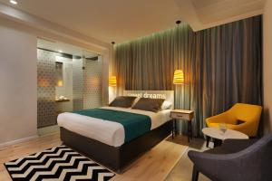 a bedroom with a bed and a desk and a chair at Prima City Hotel in Tel Aviv