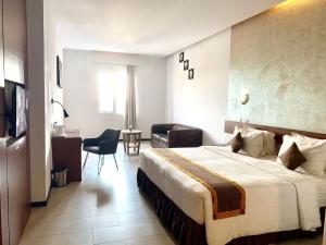 Xtra Hotel Bengkulu في بنجكولو: غرفة فندقية بسرير كبير وكرسي