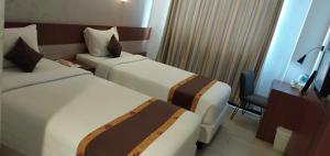 Postel nebo postele na pokoji v ubytování Xtra Hotel Bengkulu