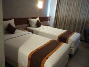 Postel nebo postele na pokoji v ubytování Xtra Hotel Bengkulu