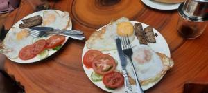 two plates of breakfast food on a wooden table at Tran Chau Garden Home in Cat Ba