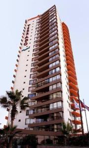 a tall apartment building with an orange at Amoblados MyK playa brava club in Iquique