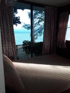 a bedroom with a bed and a view of the ocean at Sea Gate Beach Resort in Thong Sala
