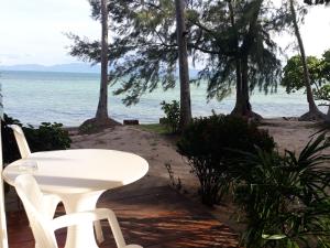 a white table and chairs on the beach at Sea Gate Beach Resort in Thongsala